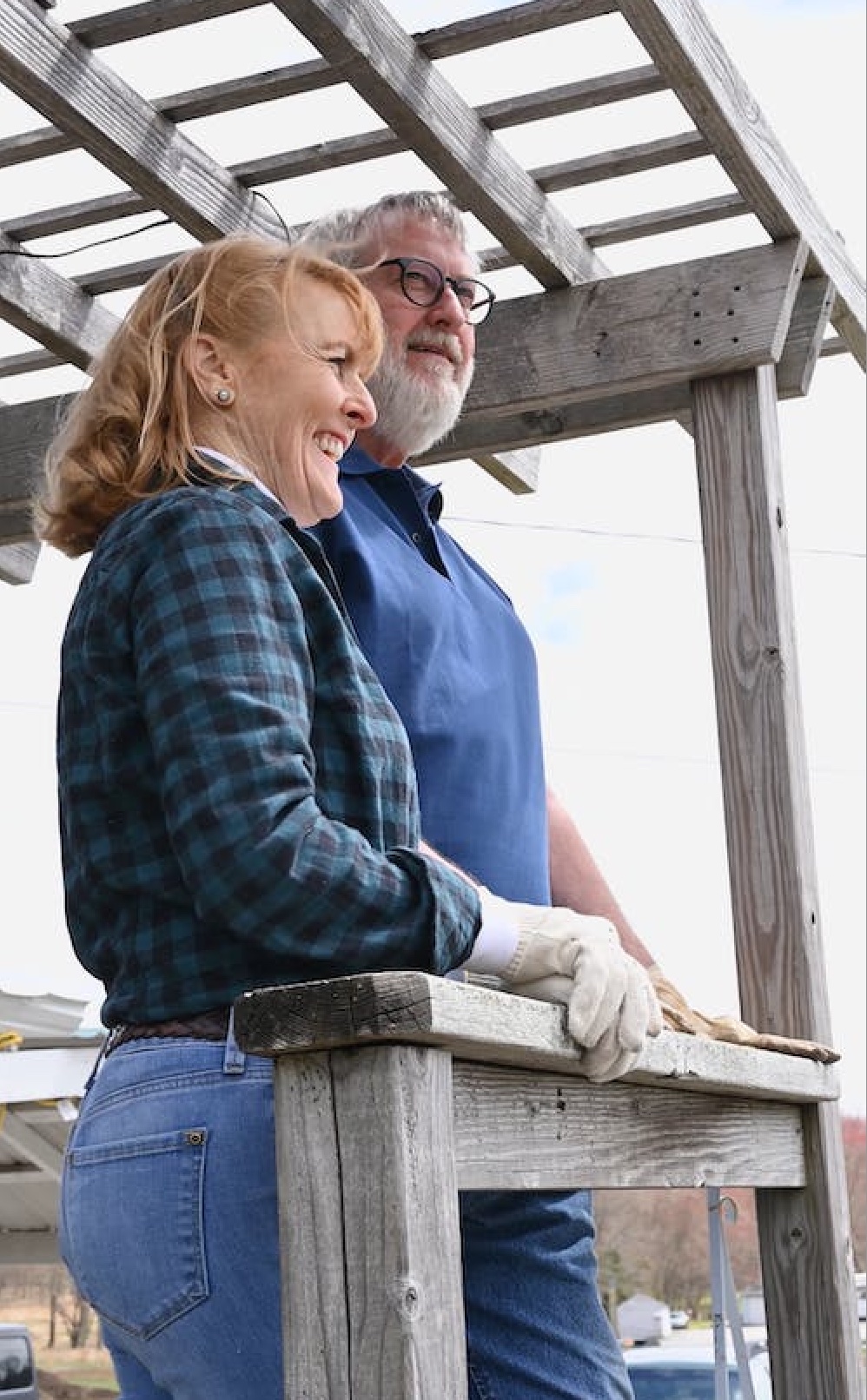 middle aged couple standing outside on a deck